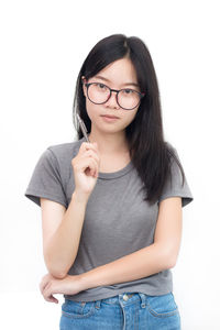 Portrait of smiling young woman against white background