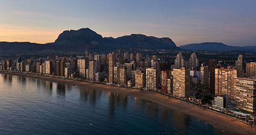 Panoramic view of city and mountains against sky during sunset