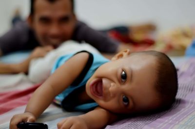 Portrait of cute baby lying on bed