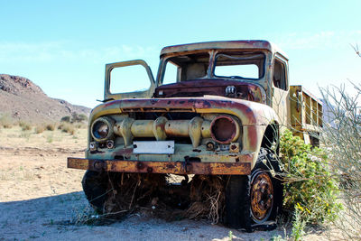 Abandoned truck on field against sky