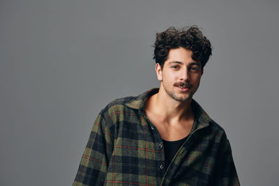 Portrait of young man standing against white background