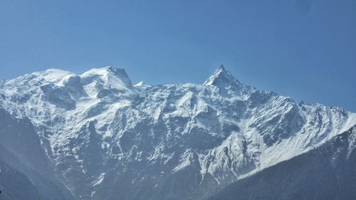 Scenic view of snowcapped mountains against clear blue sky