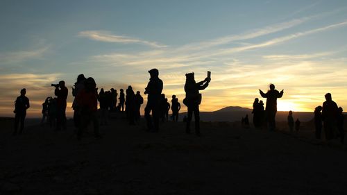 Silhouette people on beach during sunset