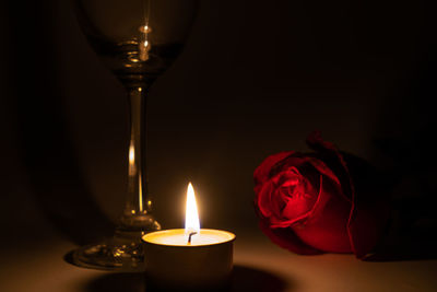 Close-up of illuminated red rose on table