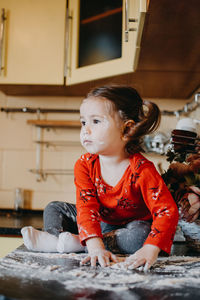 Full length of cute baby girl sitting at home