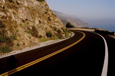 Road leading towards mountain against sky