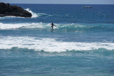Man surfing in sea against sky