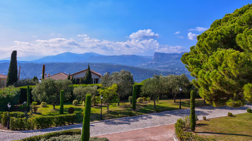 Scenic view of trees and mountains against blue sky