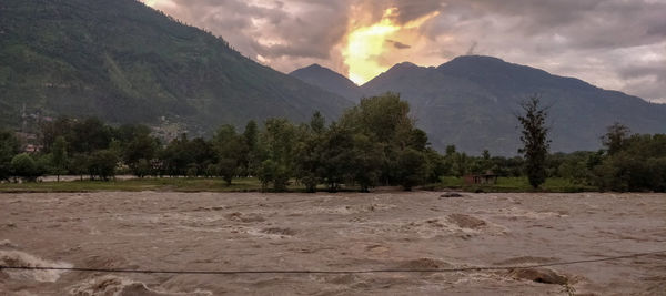 Scenic view of field and mountains against sky