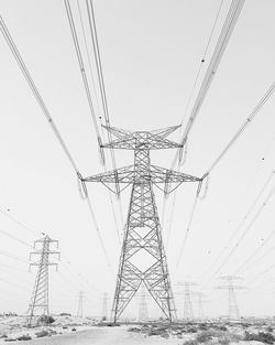 Low angle view of electricity pylon against clear sky