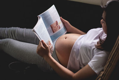 Midsection of woman reading book