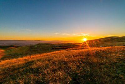 Scenic view of field against sky during sunset