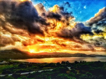 Scenic view of sea against dramatic sky during sunset