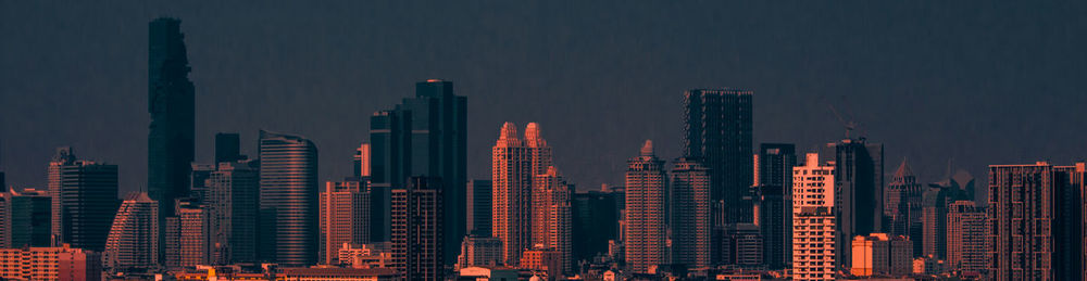 Modern buildings in city against sky at night