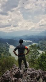 Rear view of woman looking at mountain against sky