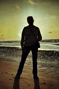 Rear view of people standing on beach