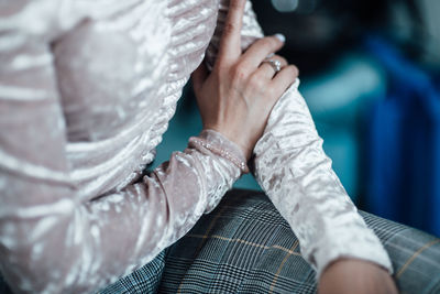 Midsection of woman wearing dress sitting on chair