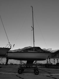 Sailboats moored on shore against sky