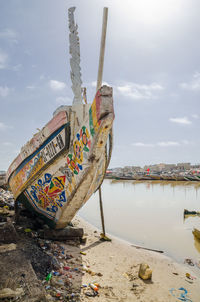 Multi colored boats moored on beach against sky