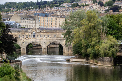 Arch bridge over river against buildings