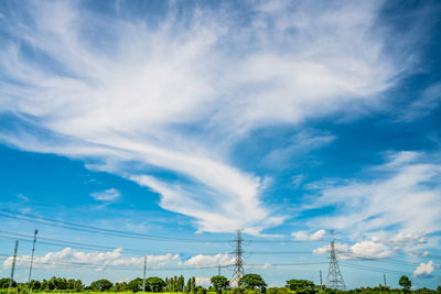 Low angle view of electricity pylon against blue sky