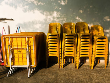 Stacked yellow chairs against wall