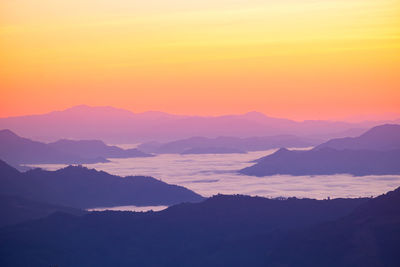 Scenic view of silhouette mountains against romantic sky at sunset