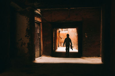 Silhouette boy walking in building