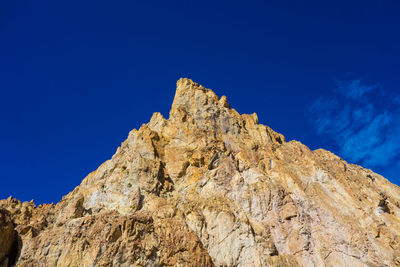 Low angle view of rock formation against blue sky