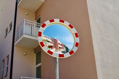 Low angle view of mirror against buildings in city