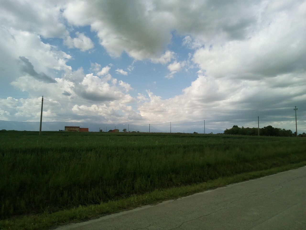 cloud - sky, sky, environment, landscape, field, road, grass, land, plant, nature, day, beauty in nature, transportation, no people, tranquil scene, tranquility, rural scene, scenics - nature, green color, outdoors