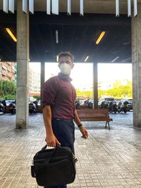 Full length of young man standing against built structure