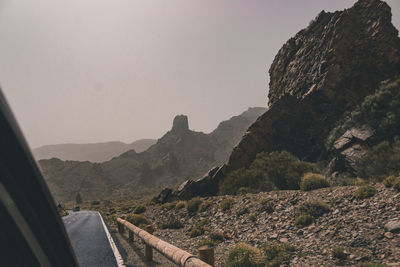 Road by mountains against clear sky