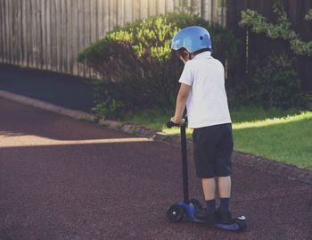 Full length of boy skateboarding on road