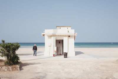 Man on beach against clear sky