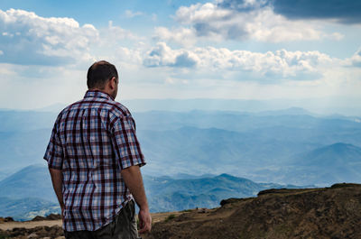 Man standing on mountain against sky