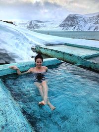 Full length of young woman enjoying in swimming pool