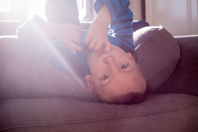 Portrait of boy relaxing on sofa at home