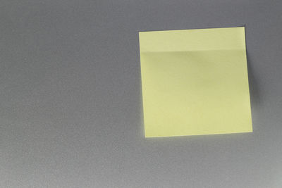 Close-up of yellow paper on wall