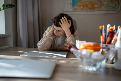 Young woman using mobile phone at table