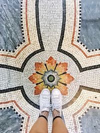 Low section of woman standing on tiled floor