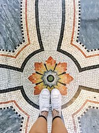 Low section of woman standing on tiled floor