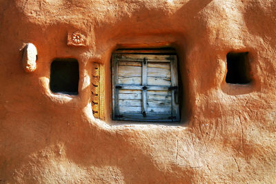 Closed wooden window of old mud hut