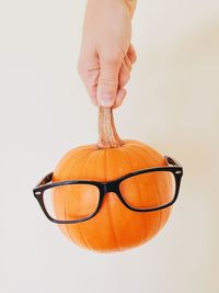 Close-up of hand holding object over white background