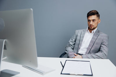 Portrait of businessman using laptop at office