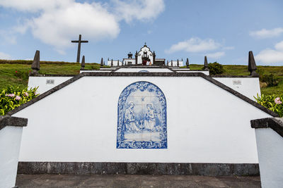 Low angle view of cross on building against sky