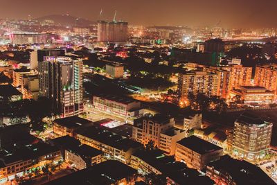 High angle view of illuminated cityscape against sky at night