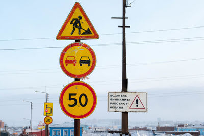 Low angle view of road sign against sky