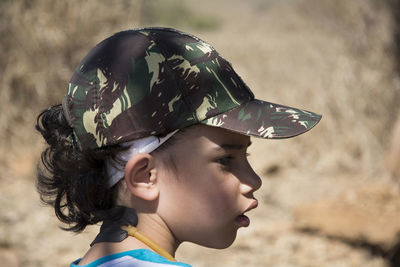 Close-up of boy wearing camouflage cap on field