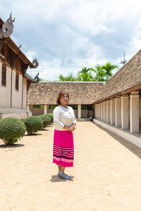 Portrait of smiling woman standing against building